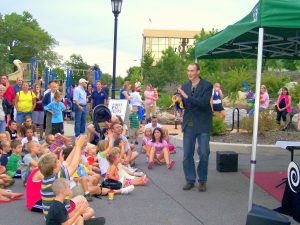 A man in front of a crowd of children doing magic tricks